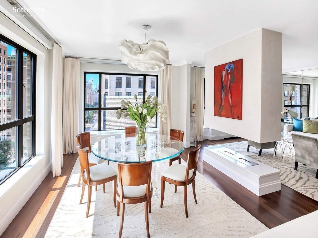 Dining area — open-flow connection to the living room, arched-cloud light fixture, casement windows looking out across Park Avenue
