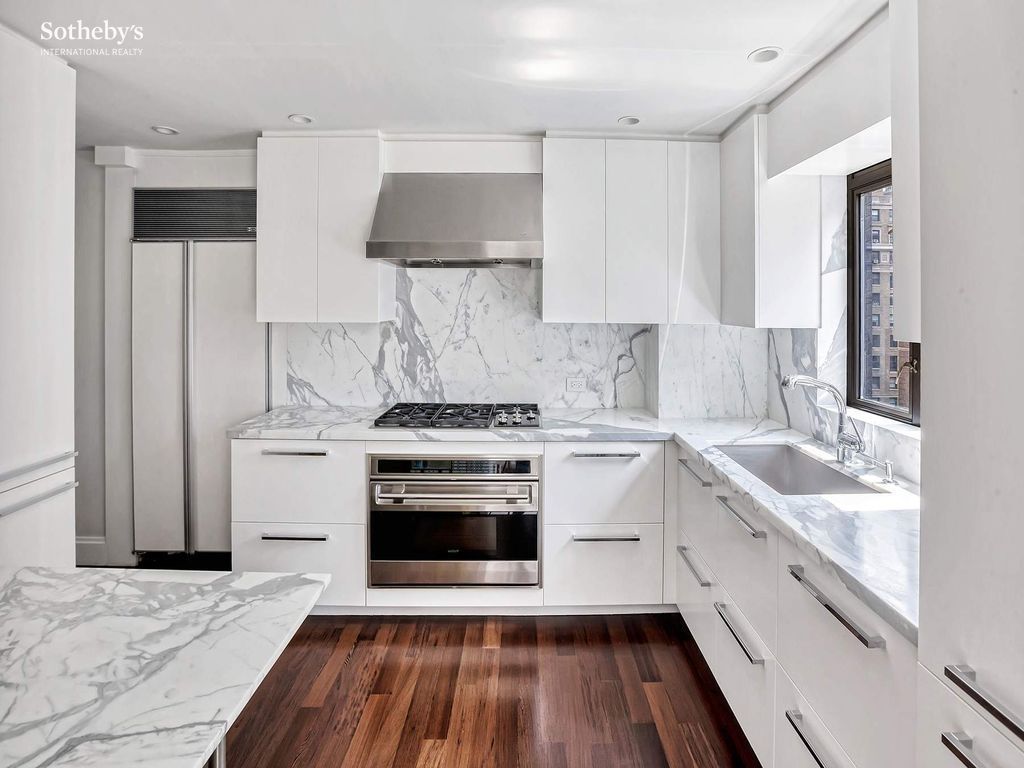 Renovated kitchen — stainless appliances, custom cabinetry, open-plan integration