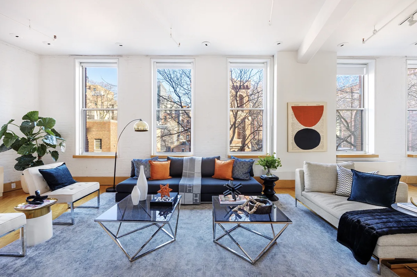 285 Lafayette Street — open living room with cast-iron column visible at right, four-window exposure, tall ceilings, the apartment's architectural anchor