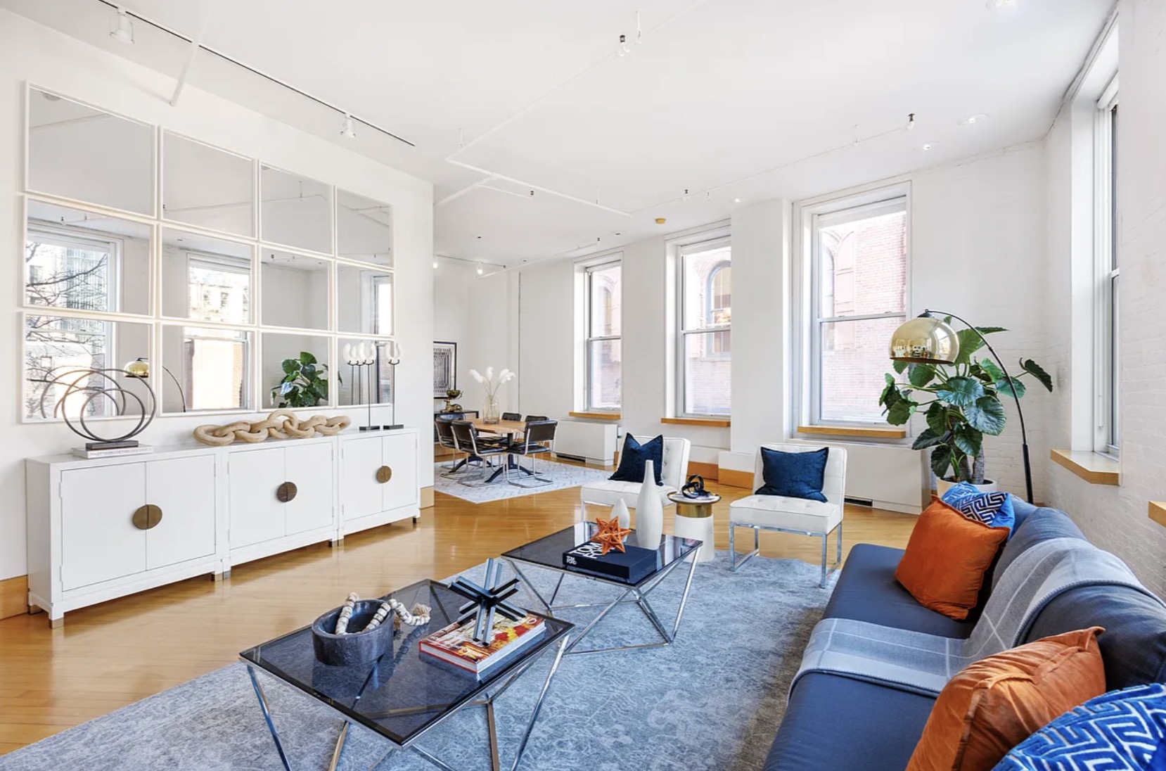 Dining and living area — mirrored built-in cabinetry, the column as architectural anchor