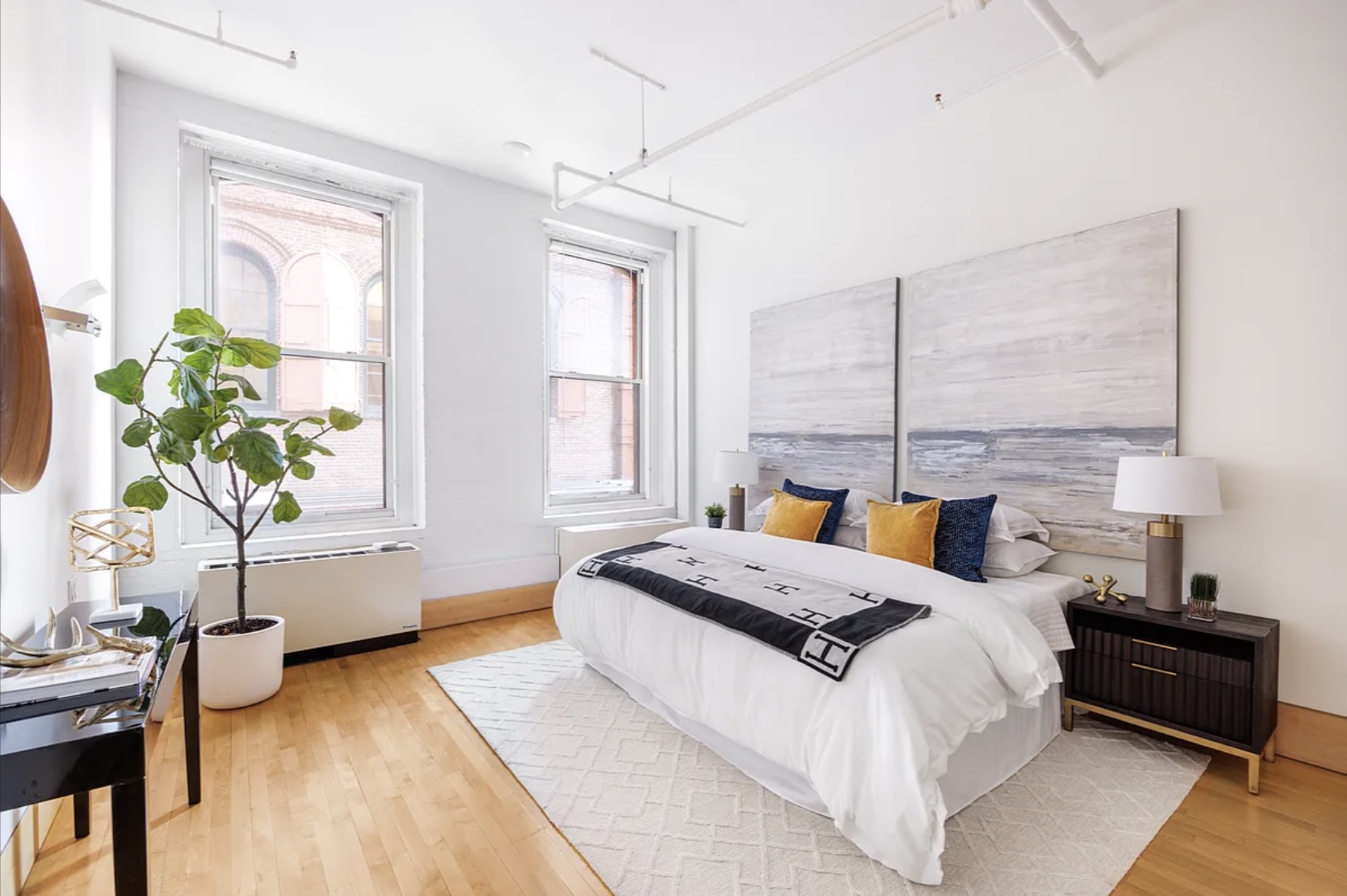 Primary bedroom — tall ceilings, exposed structural detailing, substantial windows