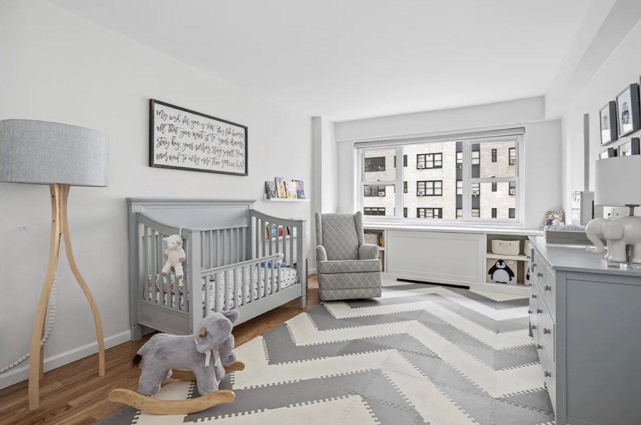 The second bedroom configured as a nursery — the family-forming use case the apartment supports at the Sutton Place co-op price tier