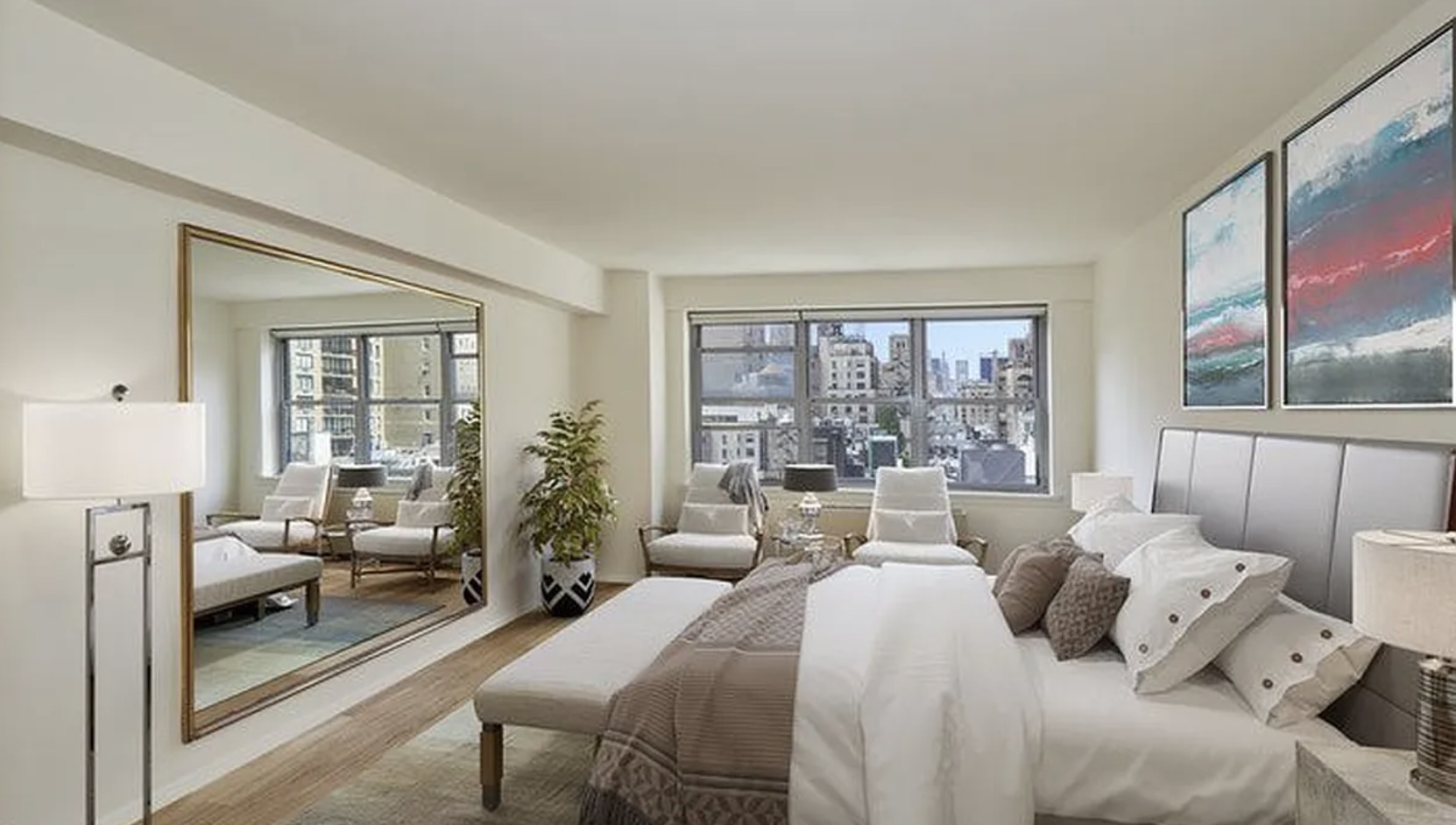 The primary bedroom — oversized windows with the same skyline view, the apartment's signature room