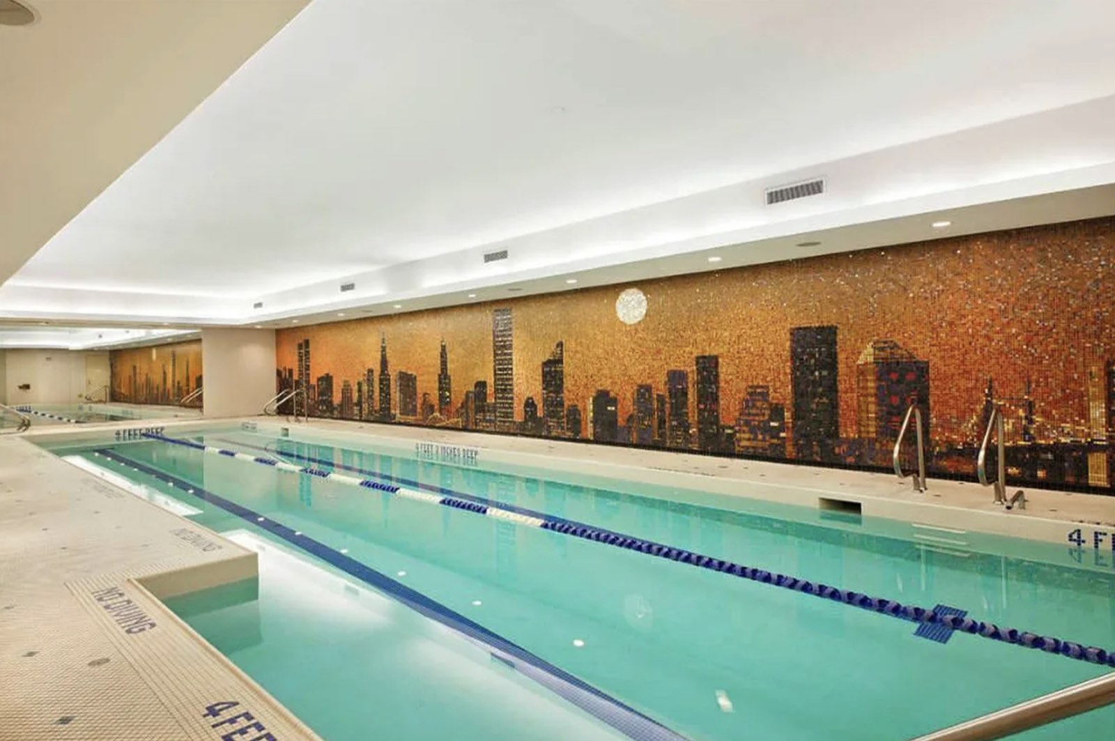 The indoor lap pool at 845 United Nations Plaza, beneath a mosaic of the Manhattan skyline