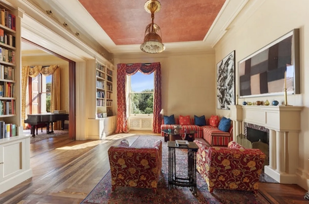 A parlor at the Dakota, with a coffered ceiling, fireplace and built-in bookshelves